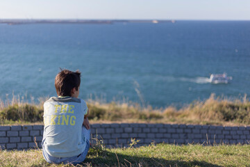 Boy from behind looking at the sea