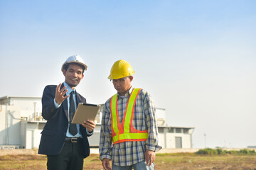 Asian Engineer using tablet working on site construction