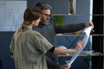 Engineer team working in office with blueprints and architect equipment, sketching, negotiating and planning construction project. Partners discussing at work. Business construction concept.