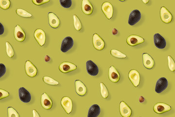 Avocado. Background made from isolated Avocado pieces on olive color background. Flat lay of fresh ripe avocados and avacado pieces.