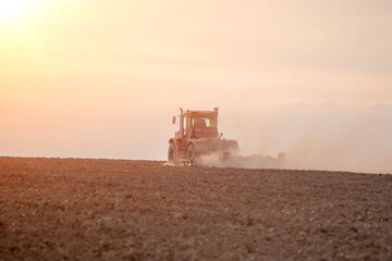 Fototapeta premium tractor in the field plows the land