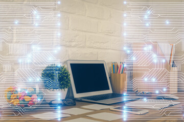 Computer on desktop in office with technology theme hologram. Double exposure. Tech concept.