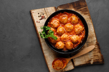 Meatballs in a pan in sweet and sour tomato sauce