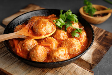 Meatballs in a pan in sweet and sour tomato sauce