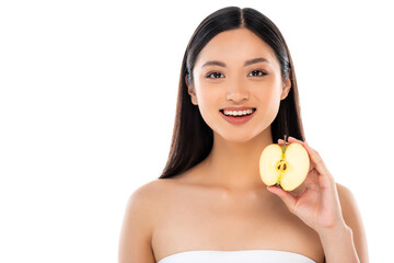 Obraz na płótnie Canvas brunette asian woman looking at camera while holding half of ripe apple isolated on white