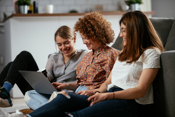 Happy businesswomen talking and laughing in office. Beautiful women drinking coffee in the office.
