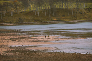 Two people walking on the beach, Applecross Bay, Scottish highlands