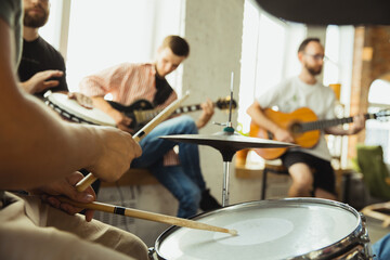 Songs. Musician band jamming together in art workplace with instruments. Caucasian men and women, musicians, playing and singing together. Concept of music, hobby, emotions, art occupation.