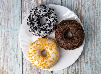 Donuts on a white plate on a wooden table