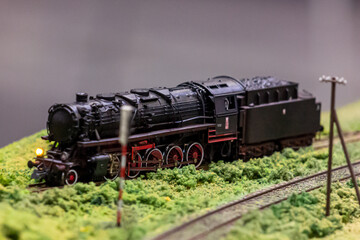 A steam locomotive maneuvering on a railway siding. Model of a steam locomotive at a railway station.