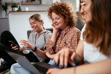Happy businesswomen talking and laughing in office. Beautiful women drinking coffee in the office.