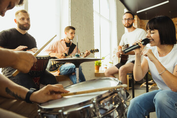 Festival. Musician band jamming together in art workplace with instruments. Caucasian men and...