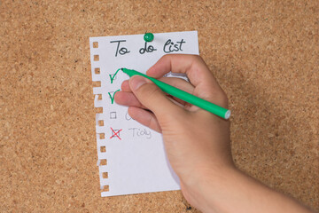 Hand drawing a check in a box. To do list of household chores.