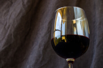 Full red wine glass on the dark and gray background