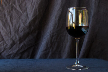 Full red wine glass on the dark and gray background