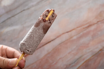 hand holding a red bean popsicle with some bites