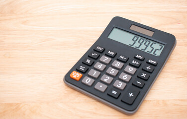 Top view Black digital calculator on wood background