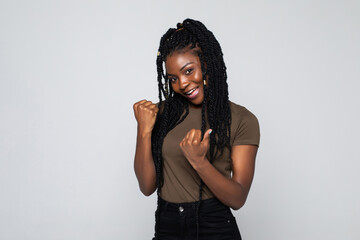 Excited young african american woman feeling overjoyed isolated on grey studio background. Lucky...
