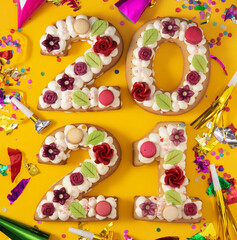 Fototapeta na wymiar 2021 cake and ornaments isolated on yellow background. New year concept. 