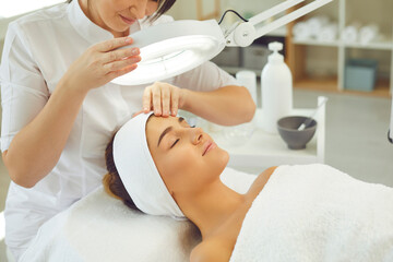 Relaxed young woman enjoying professional skincare procedures in modern beauty salon