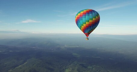 Colorful hot air balloon epic flying above mountain over the fog at sunrise with beautiful sky background - High altitude aerial drone wide view