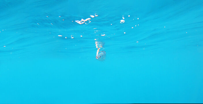 Fish hooked to lure by kayaker trolling fishing. Underwater view of a oblade fish hooked to a lure being pulled out of water by a fisherman standing on a kayak off the coast of Calblanque Beach.