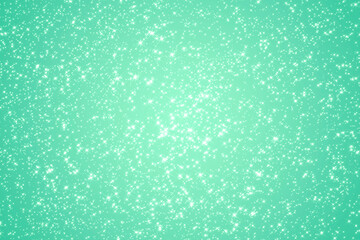 green festive bright shining background with many small stars scattered chaotically. Luxurious universal background for the design of congratulations, banners, cards, invitations.