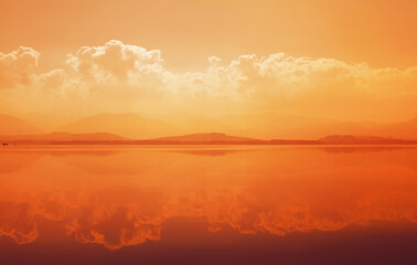 Sunset over mountain lake with reflection