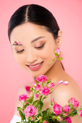 young asian woman with tiny roses and floral decoration on face isolated on pink