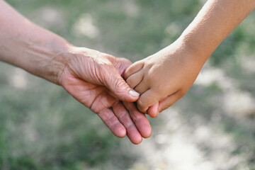 Grandmother and child hold hands. 