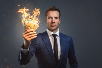 Businessman holding burning money in his hand