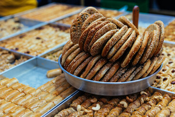 Traditional arabic sweets and bakery (dessert kadaif, kunafa, baklava, simits) in the Jerusalem market, Israel. - obrazy, fototapety, plakaty