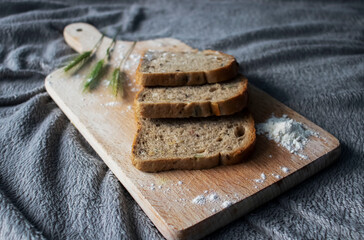 
Bread lies on a kitchen board and spikelets of wheat