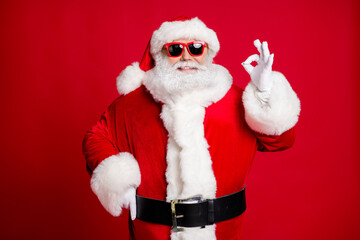 Portrait of his he nice handsome content cheerful cheery bearded Santa father showing ok-sign celebratory solution decision isolated over bright vivid shine vibrant red color background