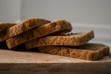 
Bread lies on a kitchen board and spikelets of wheat