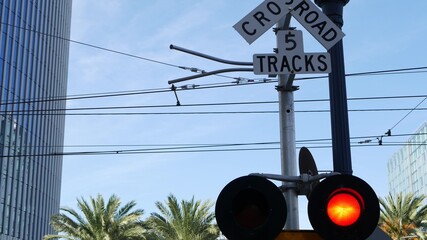 Level crossing warning signal in USA. Crossbuck notice and red traffic light on rail road...