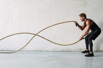 Attractive young sporty man in headphones exercising