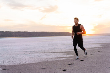 Image of caucasian athletic sportsman running while working out