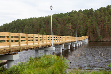 wooden pedestrian bridge over the river, with lighting poles