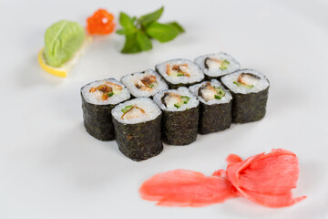 Суши красиво выложены дополнительными ингредиентами снятые на белом фоне