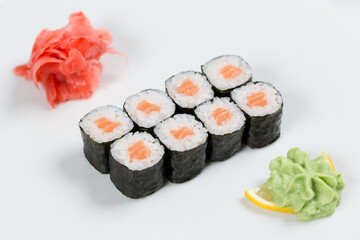 Суши красиво выложены дополнительными ингредиентами снятые на белом фоне