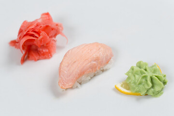 Суши красиво выложены дополнительными ингредиентами снятые на белом фоне