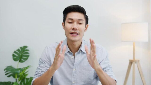 Asia businessman social distancing in new normal situation for virus prevention looking at camera presentation to colleague about plan in video call while work in office. Lifestyle after corona virus.