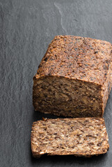 Super seed vegan loaf free from wheat and yeast on black stone background