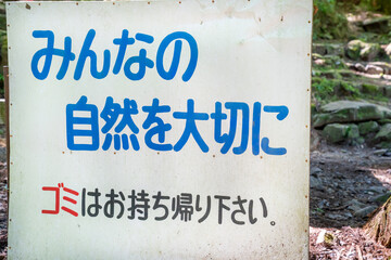 山に設置されたゴミを持ち帰ろうという看板の写真