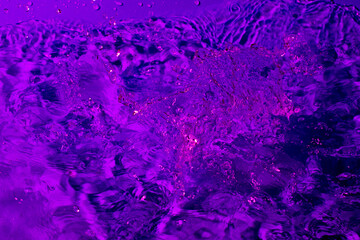 splash of water in lilac light. Abstract wallpaper