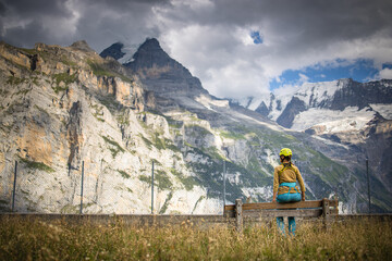 Pretty, female climber on a via ferrata - climbing on a rock in Swiss Alps