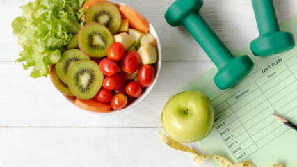 Nutrition start up workout and diet Health Plan.  Sport exercise equipment workout andÂ gym with nutrition fresh salad and green apple for fitness style. 