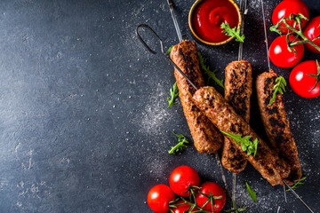 Shish kebab on skewers, from minced beef meat. Lula kebab, traditional Caucasian recipe. On black...