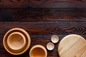 Making wooden dishes. Empty bowls on brown wooden background top view copy space